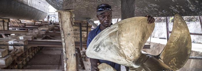 Werknemer uit Sierra Leone aan het werk op de scheepswerf